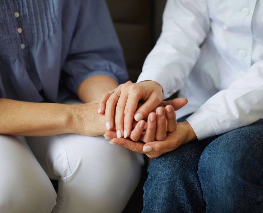 Immagine che pone il focus su una dottoressa che stringe le mani di una donna