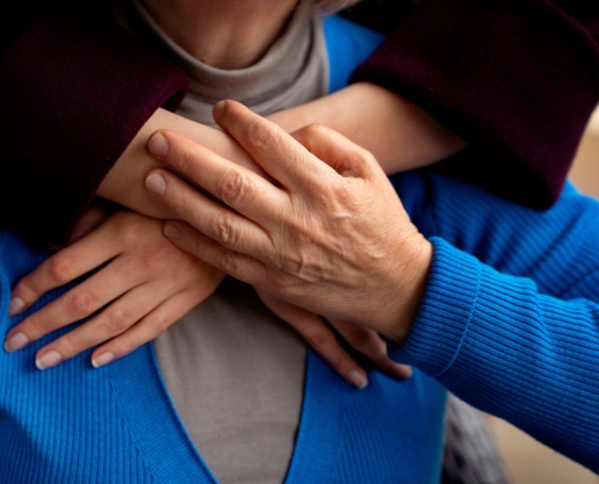 Focus su donna che abbraccia un uomo anziano di spalle